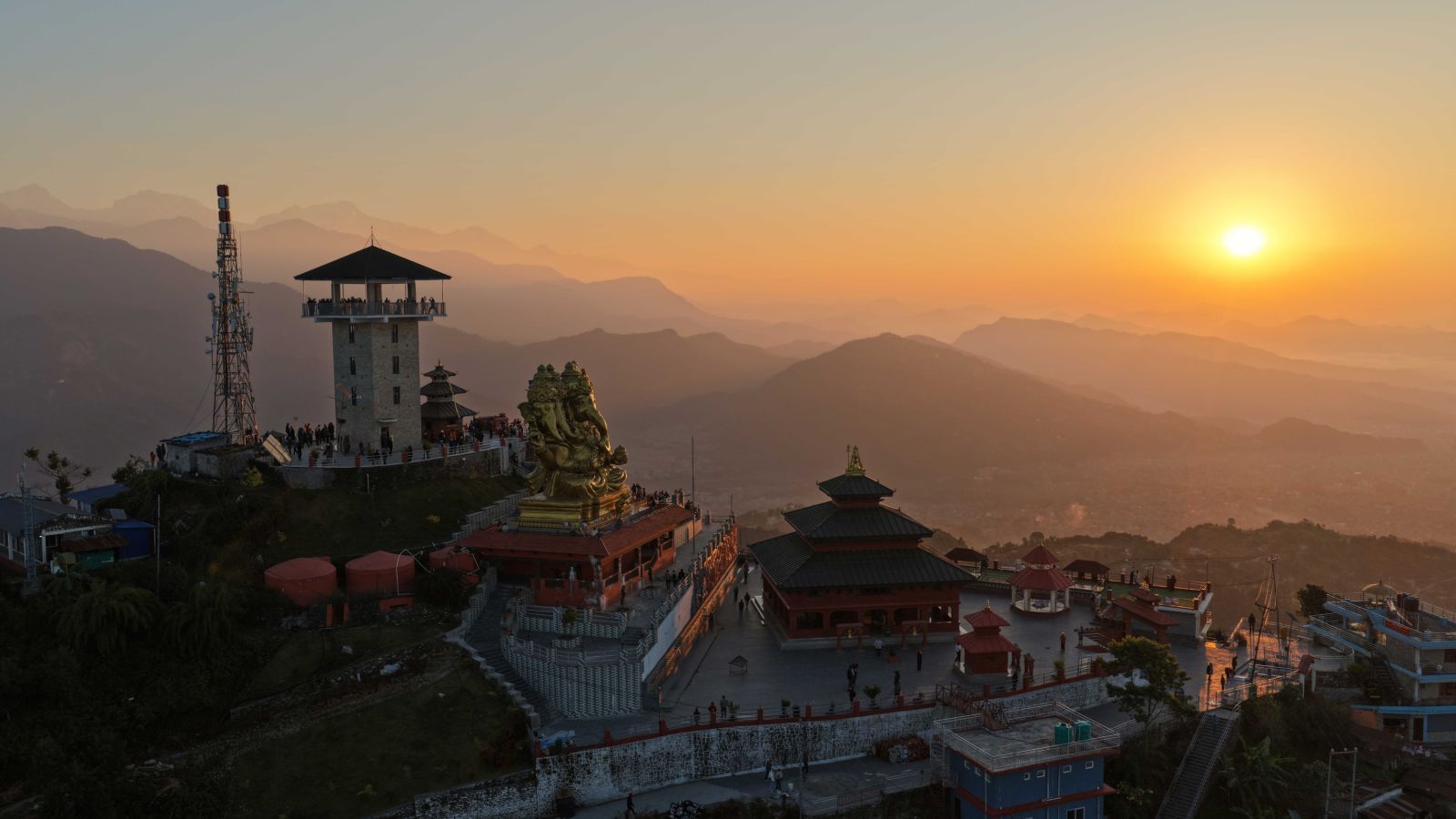 A vibrant aerial view of the Sarangkot view tower and pagoda temple in a beautiful sunrise in the sky.